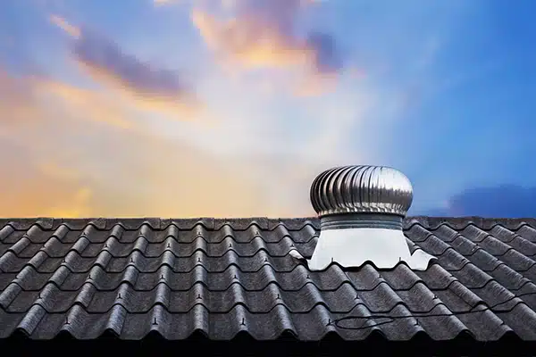 Attic fan on top of a roof.