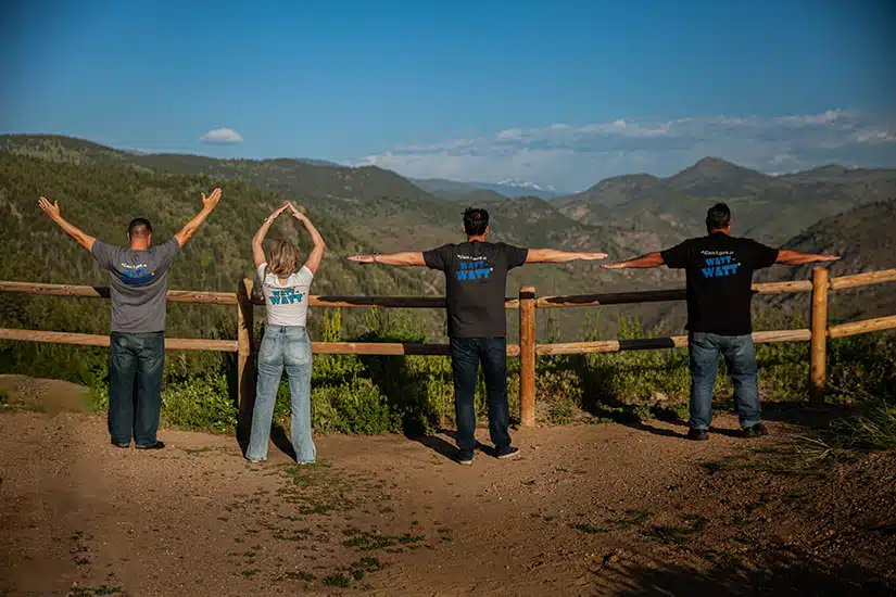 Professional power team standing on a mountain in CO.