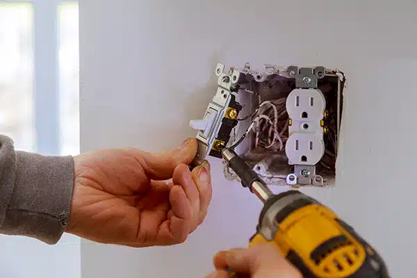 An electrician installing a light switch